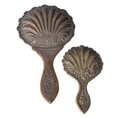 two decorative metal objects on a white background, one is shaped like a fan and the other is shaped like a scallop