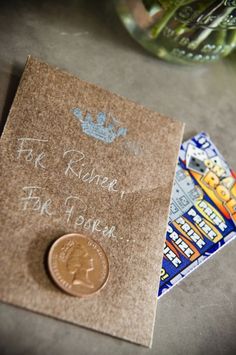 a penny sitting on top of a piece of paper next to a card with writing