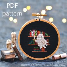 a cross - stitch pattern with a ghost on it next to some candles and other items