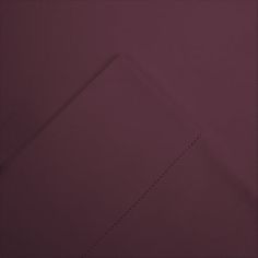 the corner of a piece of paper with lines drawn on it, in front of a purple background