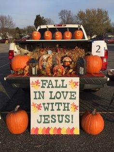 a truck with pumpkins on the back and a sign that says fall in love with jesus