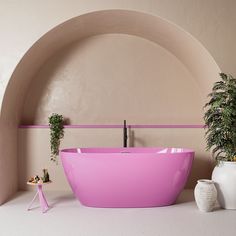 a pink bath tub sitting next to a potted plant on top of a table