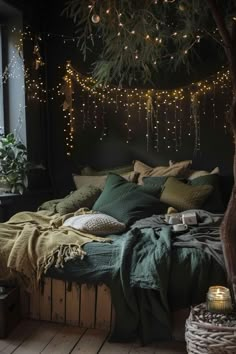 an unmade bed in a dark room with string lights hanging from the ceiling above it