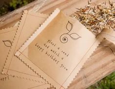 three pieces of brown paper sitting on top of a wooden table next to dry grass