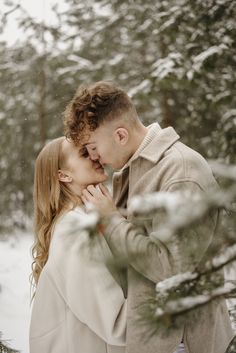 a man and woman kissing in the snow