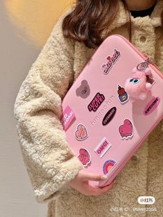 a girl holding a pink suitcase with stickers on it