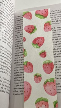 an open book with watercolor drawings of strawberries and leaves on the pages,