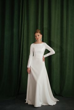 Wedding dress in a modest and minimalistic style! A minimalistic, modest wedding dress with long sleeves would be perfect for autumn and winter wedding crafted of high-quality crepe and decorated with bridal buttons. The boat neckline and high back complement each other, making the dress stylish and modern. This A-line elegant dress is for brides who dream of minimalistic and graceful style. The back of the wedding dress is decorated with bridal buttons that go all the way from the back to the e Bridal Buttons, Wedding Dress Cover, Elegant Bridal Dress, Graceful Style, Wedding Dress With Long Sleeves, Wedding Dress Simple, Crepe Wedding Dress, Modest Wedding Dress, Wedding Court