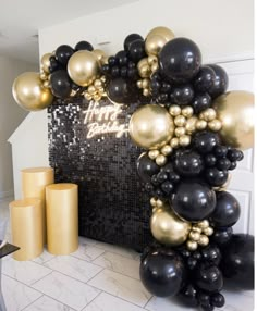 black and gold balloon arch with happy new year written on the front, surrounded by balloons