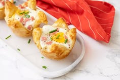 three small pastries on a white plate with a red napkin