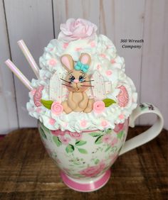 there is a cup that has a bunny in it on top of flowers and straws