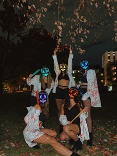 group of people dressed up in costumes posing for the camera with masks on their faces