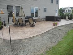 a patio with chairs and an umbrella next to a house