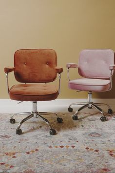 two office chairs sitting next to each other on top of a carpet