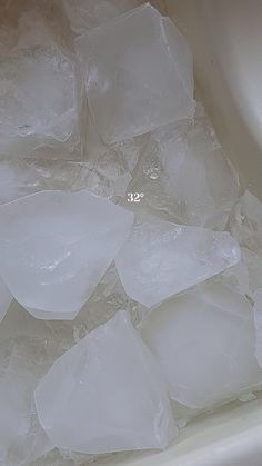 ice cubes are sitting on top of some water in a tub filled with ice