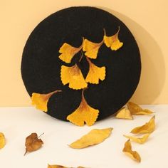 a black hat with yellow leaves on it