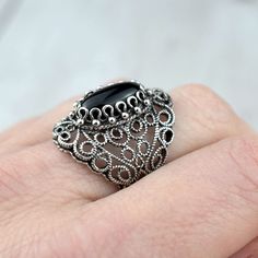 Black Onyx 925 Silver Lace Ring Artisan Made Handcrafted Filigree Art Lace Statement Ring Ring Face Length is 0.65 inches and Width is 0.30 inches Black Onyx Gemstone is 7X14 mm oval cabochon cut. This metal embroidery filigree ring is oxidized and highly polished. Comes with velvet pouch and luxurious gift box. Filigree is made of delicate metal strands that have been skillfully fashioned to create an outstanding combination of old and modern art. Originating in Mesopotamia, Anatolia. It is mad Ornate Black Sterling Silver Rings, Black Filigree Ring Jewelry, Black Ring With Intricate Design, Black Filigree Ring, Ornate Black Jewelry With Intricate Design, Ornate Black Oval Ring, Ornate Black Filigree Jewelry, Black Victorian Filigree Rings, Victorian Black Filigree Rings