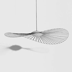 a black and white photo of a suspended light fixture in the shape of a bird's wing