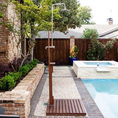 a backyard with a pool, hot tub and wooden fenced in patio area next to it