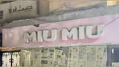 there is a sign that says umu on the side of a building with newspaper all over it