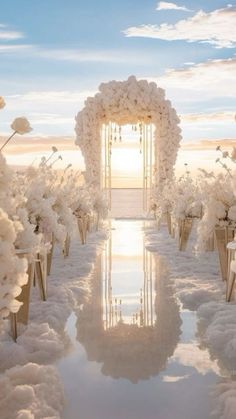 an outdoor wedding setup with white flowers and greenery on the ground, in front of a blue sky