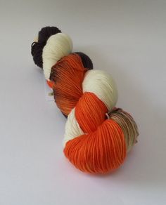 two skeins of yarn sitting next to each other on a white table top