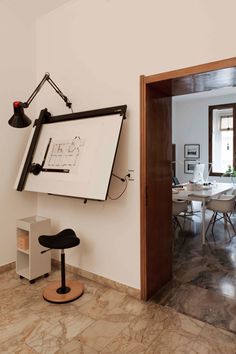 a room with a large white board on the wall next to a desk and chair