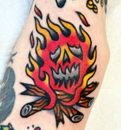 a close up of a person's foot with tattoos on it and flames in the background