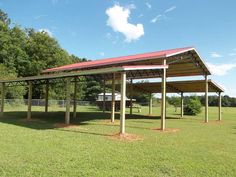 a covered picnic area in the middle of a field