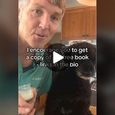 a man holding a cup next to a black dog in a kitchen with the caption, i encourages you to get a copy of free book links in the bio