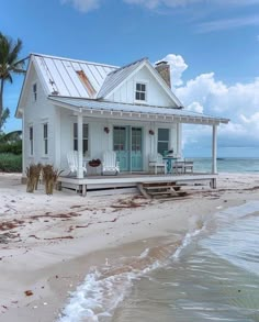 a white house sitting on top of a sandy beach