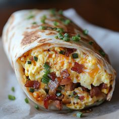 a burrito filled with eggs, bacon and green onions