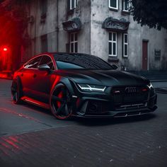 a black and red car parked on the side of a road next to a building