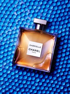 a bottle of perfume sitting on top of a blue surface