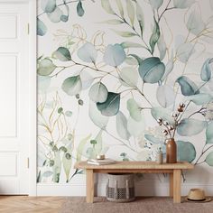 a room with a bench and wallpaper that has green leaves on it