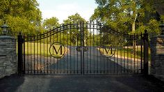 an iron gate with the initials m and v on it in front of a driveway