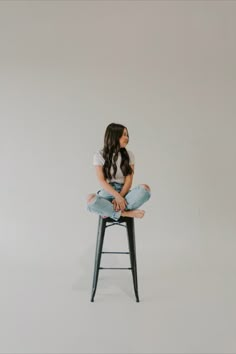 a woman sitting on top of a stool