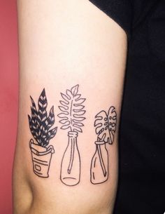 a woman's arm with three vases and plants in them on her left side