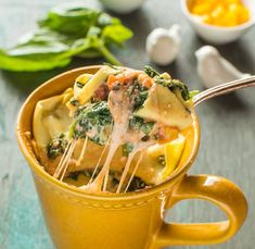 a yellow cup filled with pasta and spinach