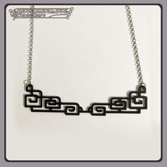 a black and white necklace with an intricate design