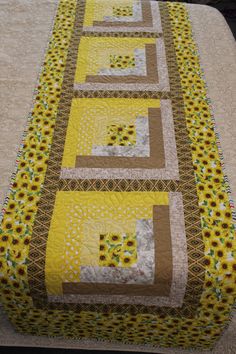 a quilted table runner with sunflowers on it