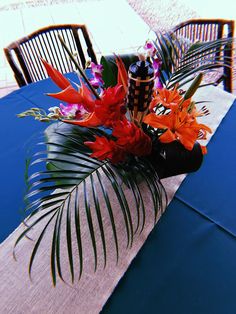 an arrangement of tropical flowers on a table