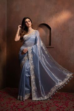 Indulge in the pure luxury of our Hand Embroidered Blue Tissue Organza Saree. Each thread is carefully and meticulously embroidered by hand, creating a one-of-a-kind piece that exudes elegance and sophistication. Elevate your style and make a statement with this exclusive saree. SKU: 0005 Luxury Tissue Silk Saree With Motifs, Luxury Chinon Saree With Chikankari Embroidery, Luxury Embroidered Festive Traditional Wear, Elegant Tissue Silk Fabric With Intricate Embroidery, Elegant Blue Blouse Piece With Intricate Embroidery, Elegant Embroidered Tissue Silk Traditional Wear, Elegant Embroidered Silk Fabric For Designer Wear, Elegant Tissue Silk Blouse With Floral Embroidery, Embroidered Light Blue Dupatta For Reception