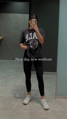 a woman taking a selfie in front of a mirror with the words new day, new workout on it