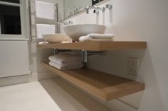 a bathroom with a sink, mirror and towel rack on the counter top in front of it