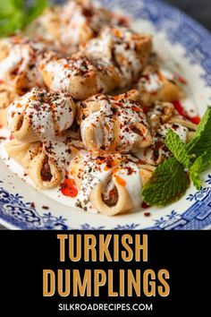 turkish dumplings on a blue and white plate with mint garnish in the middle