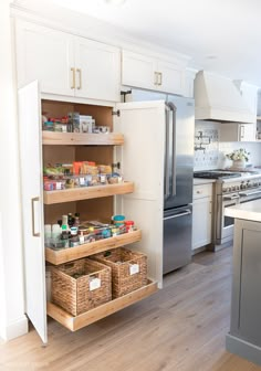 a kitchen with white cabinets and wooden shelves filled with food items on top of them