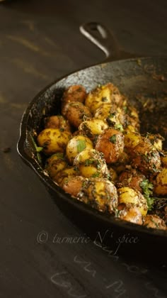 a pan filled with potatoes and herbs on top of a table