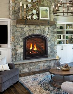 a living room filled with furniture and a fire place in front of a tv mounted on the wall