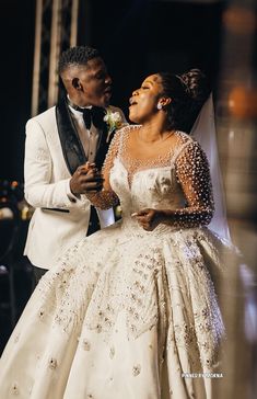 a man and woman in wedding attire standing next to each other